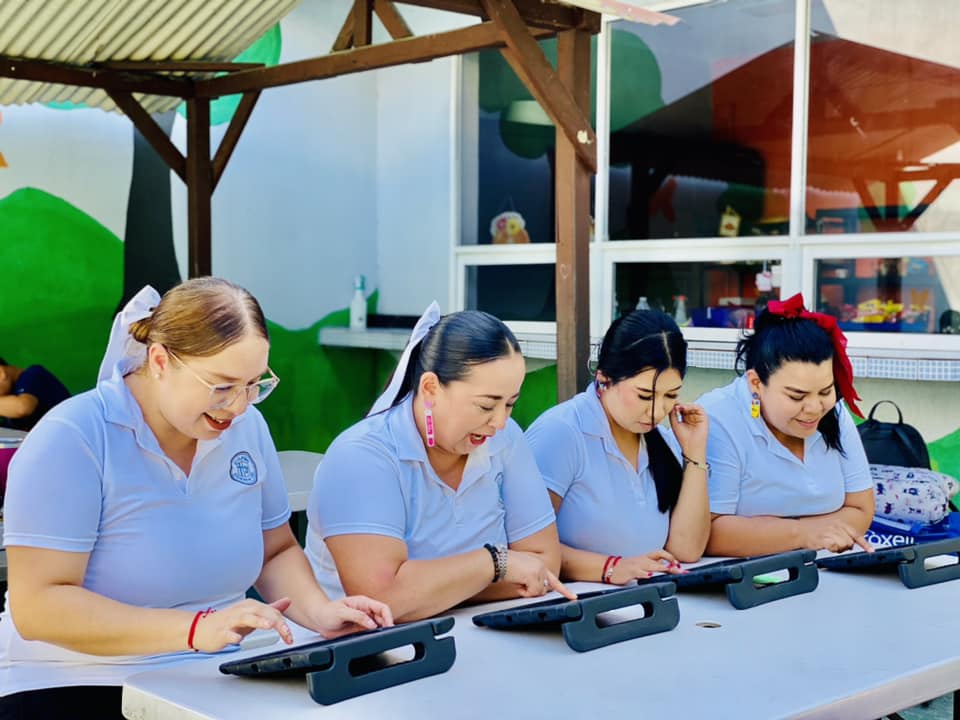 Estudiantes colaborando con tecnología en el aula